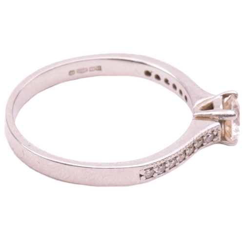 27 - A single stone diamond ring, the round brilliant cut diamond in simple four claw mount, with diamond... 