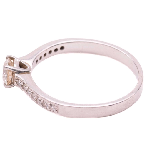 27 - A single stone diamond ring, the round brilliant cut diamond in simple four claw mount, with diamond... 