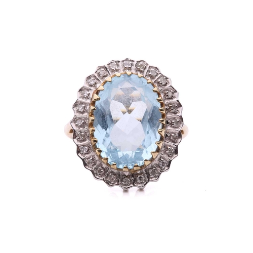 287 - A topaz and diamond cluster ring in 9ct gold, the light blue topaz measuring 3.8 x 9.7 mm, encircled... 