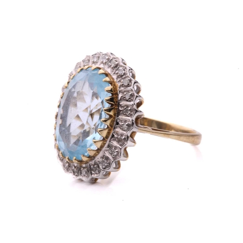 287 - A topaz and diamond cluster ring in 9ct gold, the light blue topaz measuring 3.8 x 9.7 mm, encircled... 
