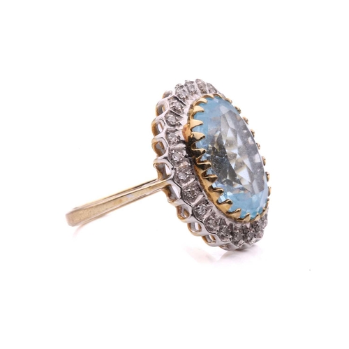287 - A topaz and diamond cluster ring in 9ct gold, the light blue topaz measuring 3.8 x 9.7 mm, encircled... 