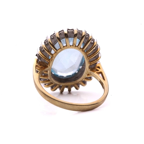 287 - A topaz and diamond cluster ring in 9ct gold, the light blue topaz measuring 3.8 x 9.7 mm, encircled... 