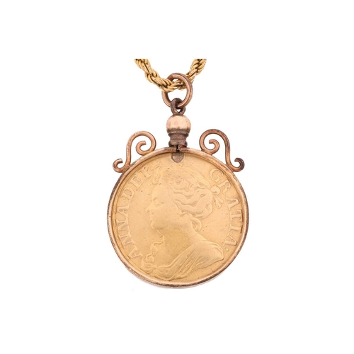 294 - A Queen Anne gold guinea in mount and an associated chain, the coin dated 1714, obverse with third d... 
