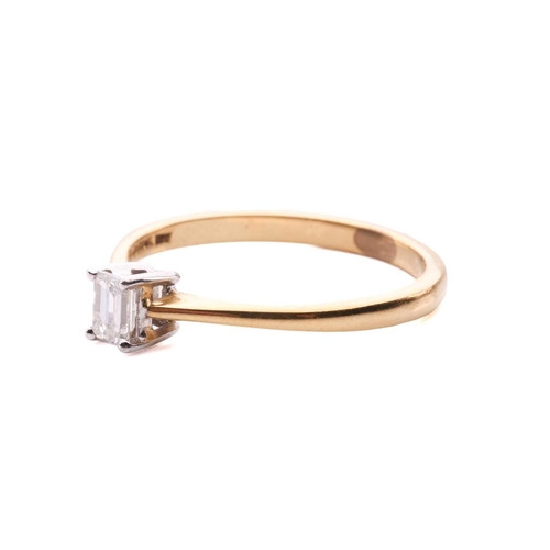 31 - A diamond solitaire ring and a crucifix pendant; the 18ct gold ring centred with an emerald-cut diam... 