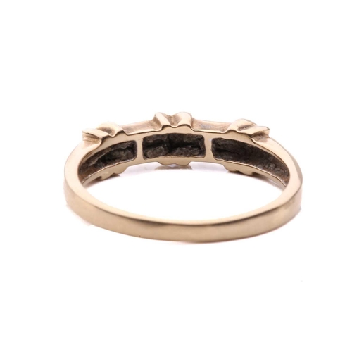 32 - A channel-set diamond ring in 14ct yellow gold, comprising three cross-lashing motifs, flanked by ro... 