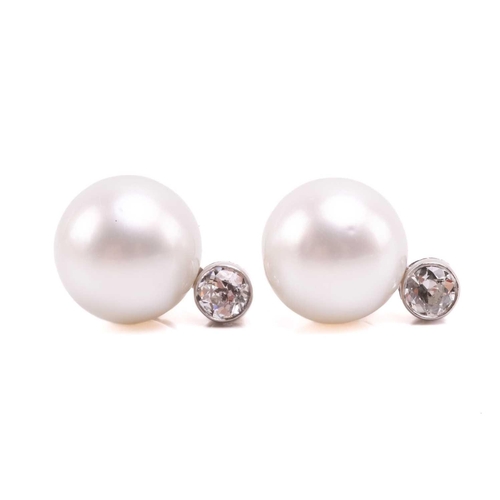 36 - A pair of pearl and diamond earrings and a ring en suite; the central single freshwater pearl flanke... 