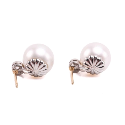 36 - A pair of pearl and diamond earrings and a ring en suite; the central single freshwater pearl flanke... 
