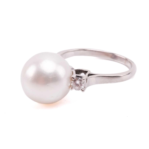 36 - A pair of pearl and diamond earrings and a ring en suite; the central single freshwater pearl flanke... 