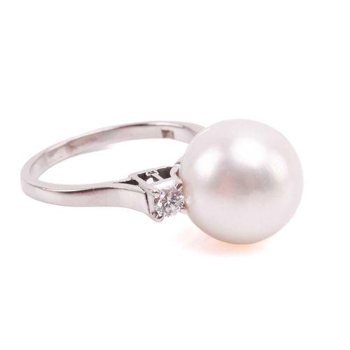 36 - A pair of pearl and diamond earrings and a ring en suite; the central single freshwater pearl flanke... 
