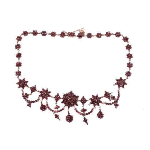 38 - A Victorian Bohemian garnet necklace, set with clusters and swags of garnets, with a length of 47cm,... 
