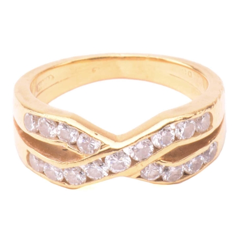 41 - A diamond cross over ring, set with two rows of round brilliant cut diamonds in a channel setting, w... 