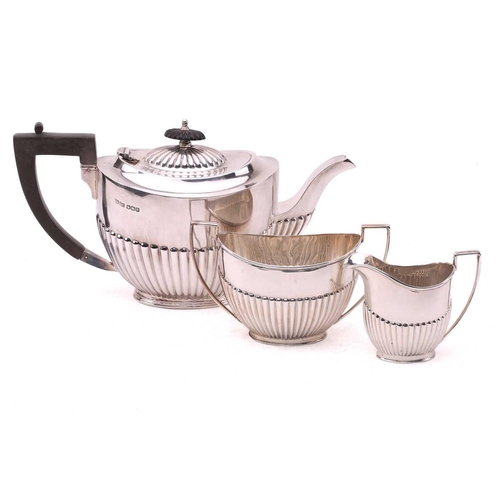 484 - A George IV-style three-piece silver tea set, with makers mark A W | J H, Sheffield 1921, of oval fo... 
