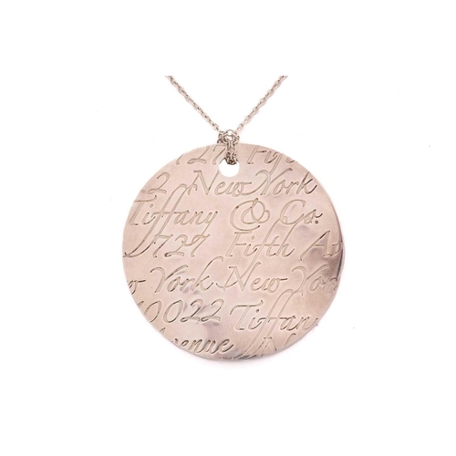 49 - Tiffany & Co. - a silver 'New York Notes' pendant on chain, the curved circular pendant engraved wit... 