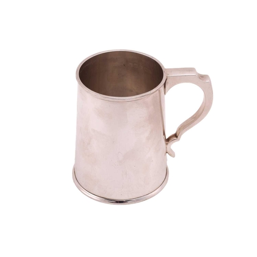 492 - A silver tankard of plain tapering cylindrical form the handle with inverted thumb piece, 11.5cm hig... 