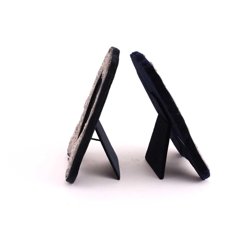 499 - A pair of silver mounted photograph frames with easel stands, the silver mounts surmounted with a he... 