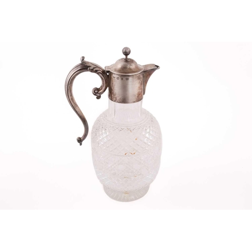 502 - A Victorian silver mounted claret jug; the domed cover with ball finial; leaf- capped scroll handle ... 