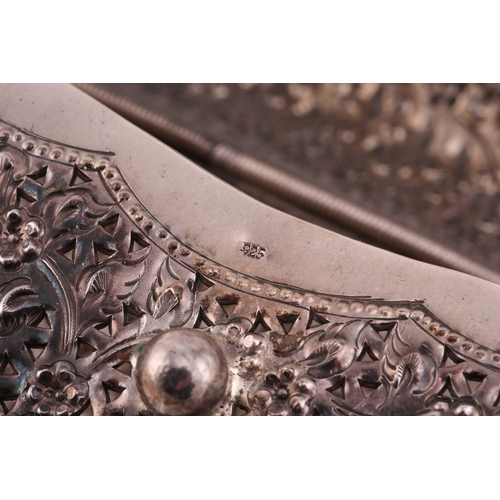 504 - A white metal clutch bag; chased and pierced foliate decoration; hinged cover and hinged clasp.Stamp... 