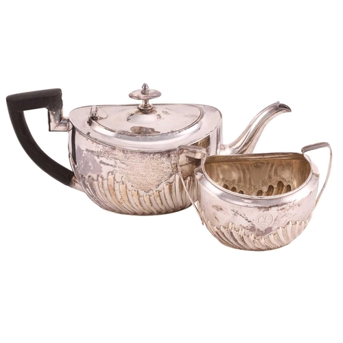 507 - A Victorian silver part-fluted teapot with angular ebonised handle, hinged cover and engraved crest ... 