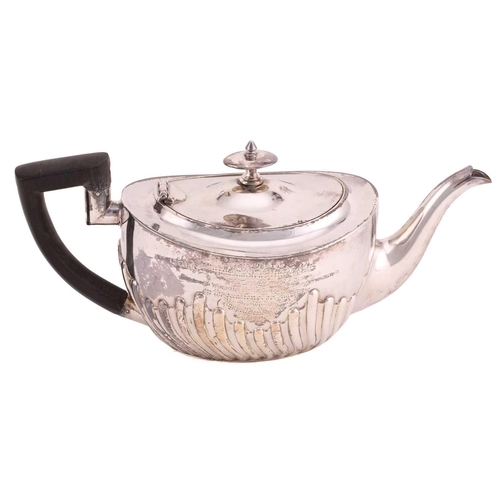 507 - A Victorian silver part-fluted teapot with angular ebonised handle, hinged cover and engraved crest ... 