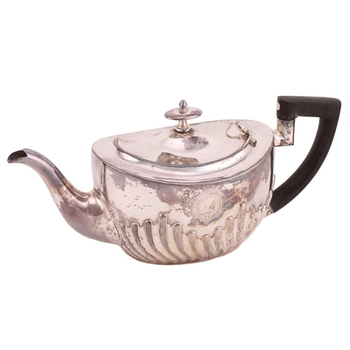 507 - A Victorian silver part-fluted teapot with angular ebonised handle, hinged cover and engraved crest ... 