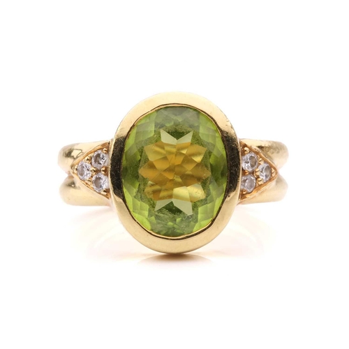 54 - A peridot and diamond dress ring, collet-set with an oval-cut peridot of 12.0 x 9.4 x 5.4 mm, flanke... 