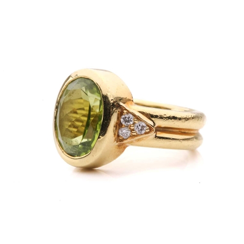 54 - A peridot and diamond dress ring, collet-set with an oval-cut peridot of 12.0 x 9.4 x 5.4 mm, flanke... 