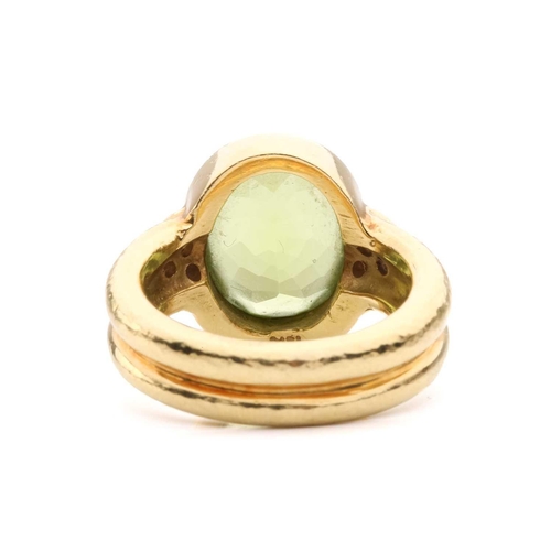 54 - A peridot and diamond dress ring, collet-set with an oval-cut peridot of 12.0 x 9.4 x 5.4 mm, flanke... 