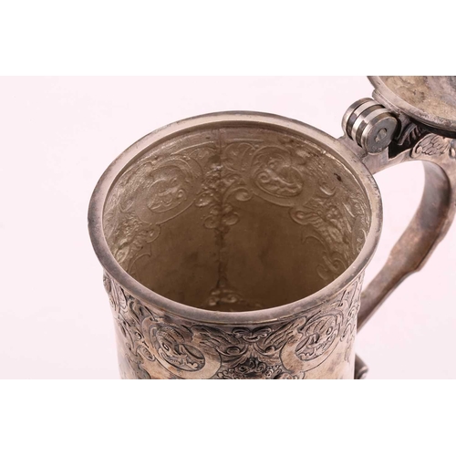 542 - A Hungarian electroplated lidded tankard. Tapering cylindrical with reeded skirt foot; the body with... 