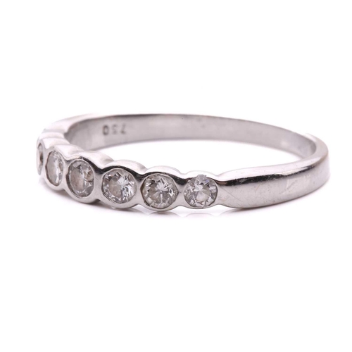 55 - A diamond seven stone half hoop eternity ring, featuring a row of round brilliant cut diamonds with ... 