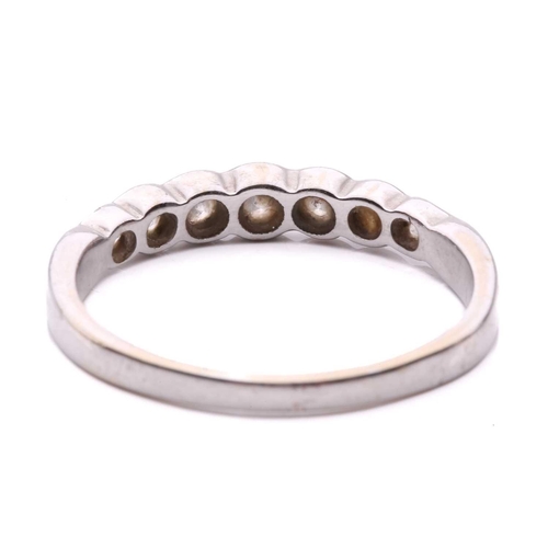 55 - A diamond seven stone half hoop eternity ring, featuring a row of round brilliant cut diamonds with ... 
