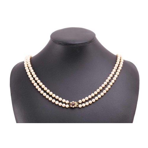 56 - A double-strand cultured pearl necklace, comprising two rows of graduated pearls with cream body col... 