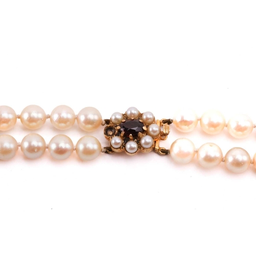 56 - A double-strand cultured pearl necklace, comprising two rows of graduated pearls with cream body col... 