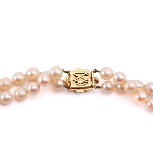 56 - A double-strand cultured pearl necklace, comprising two rows of graduated pearls with cream body col... 