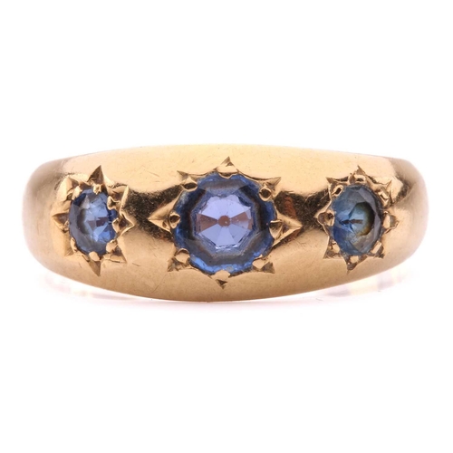 60 - An Edwardian three-stone sapphire gypsy ring in 18ct gold, star-set with three graduated circular-cu... 