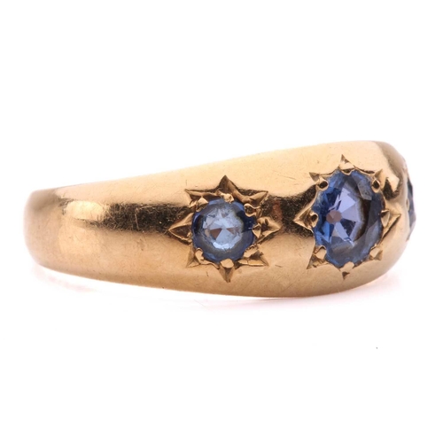 60 - An Edwardian three-stone sapphire gypsy ring in 18ct gold, star-set with three graduated circular-cu... 