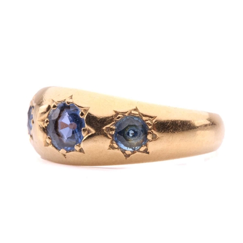 60 - An Edwardian three-stone sapphire gypsy ring in 18ct gold, star-set with three graduated circular-cu... 