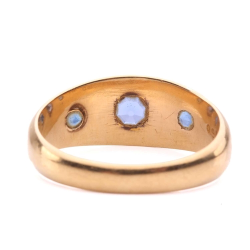 60 - An Edwardian three-stone sapphire gypsy ring in 18ct gold, star-set with three graduated circular-cu... 