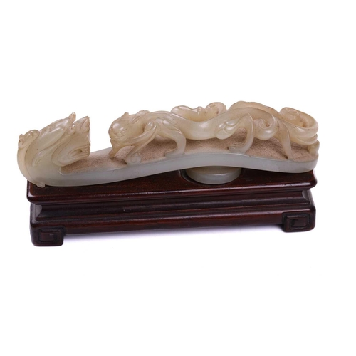 121 - A Chinese carved pale green jade belt hook, carved and pierced with sinuous Chilong and the hook ter... 