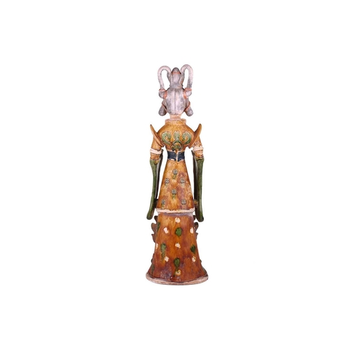 123 - A Chinese sancai glazed pottery standing court figure, Minqi, (spirit object) possibly Tang dynasty,... 