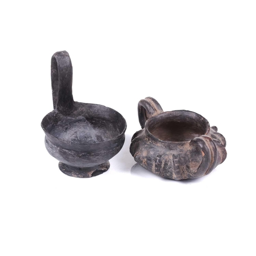 125 - A group of four Etruscan Bucchero-style black pottery vessels, including a large terracotta goblet, ... 