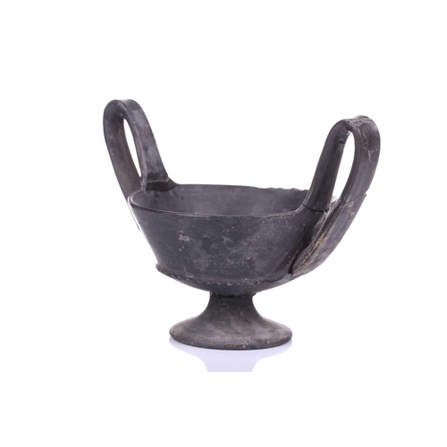 125 - A group of four Etruscan Bucchero-style black pottery vessels, including a large terracotta goblet, ... 