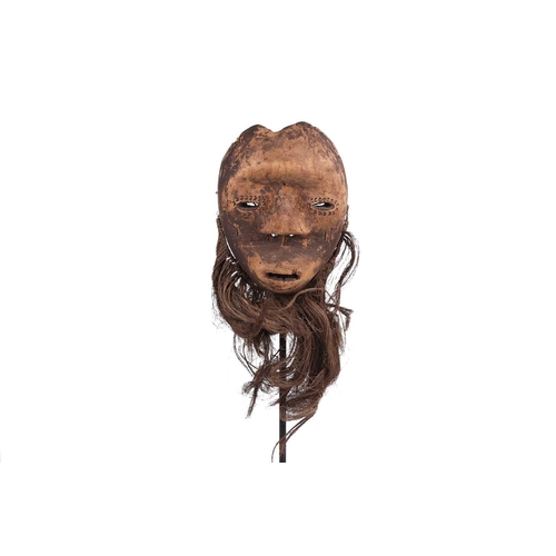 126 - A Cameroonian monkey skull fetish figure with coconut husk fibre ruff, 32 cm high and a collection o... 