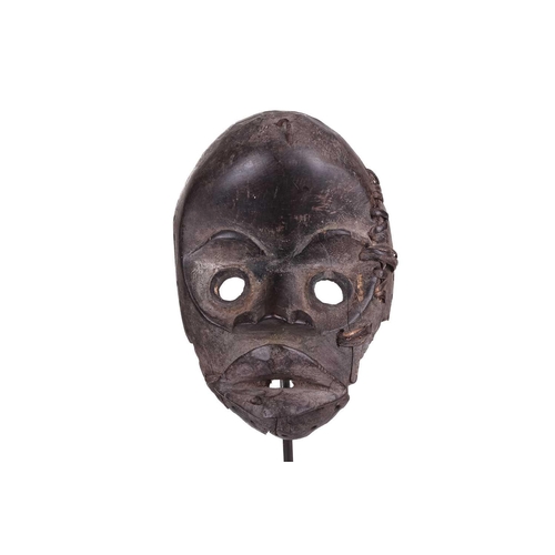 126 - A Cameroonian monkey skull fetish figure with coconut husk fibre ruff, 32 cm high and a collection o... 