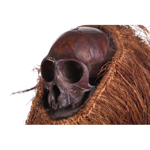 126 - A Cameroonian monkey skull fetish figure with coconut husk fibre ruff, 32 cm high and a collection o... 