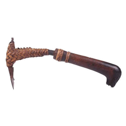 129 - An old tribal adze possibly Oceanic, with a ratan-bound iron blade fitted with naive carved wood dra... 