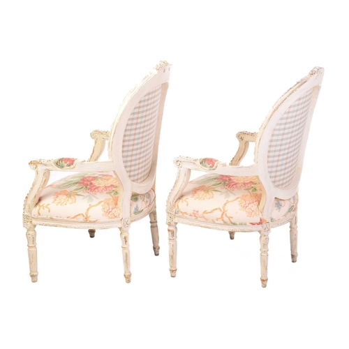 144 - A pair of Louis XVI-style carved painted and distressed fauteuils, 20th century, with cameo-shaped b... 