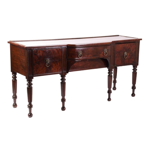 156 - A William IV mahogany breakfront sideboard, the top with plate rest to the back over a bowed centre ... 