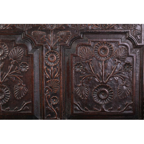 167 - An 18th century, oak settle with carved panel back and shaped arms, the seat rails with pierced rope... 