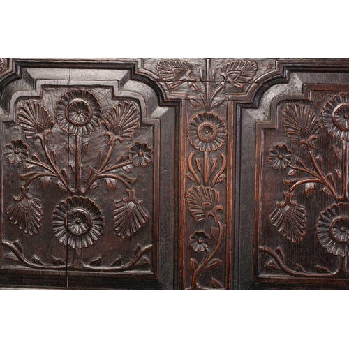 167 - An 18th century, oak settle with carved panel back and shaped arms, the seat rails with pierced rope... 