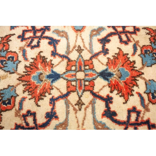 175 - An ivory-ground Najafabad carpet with overall Islimi decoration within brick red palmetted borders. ... 